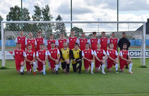 Zdjęcie pozowane: zespół PŁ na AMP na tle bramki.