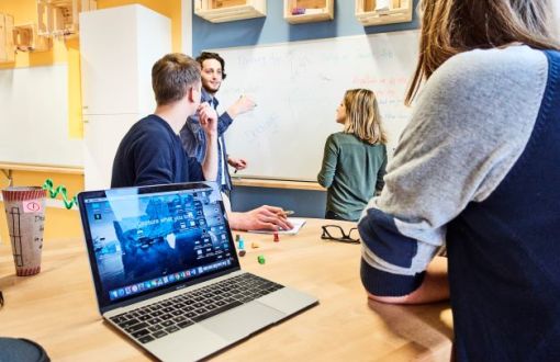 Zdjęcie poglądowe: młodzi ludzie pracujący wspólnie nad projektem.
