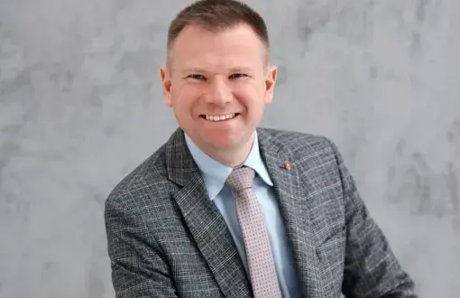 Zdjęcie portretowe: prof. Marcin Barburski na szarym tle.