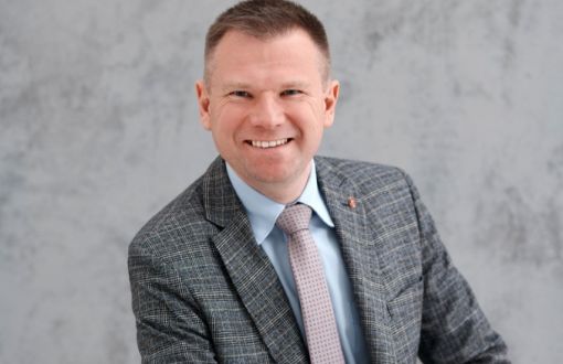 Zdjęcie portretowe: prof. Marcin Barburski na szarym tle.