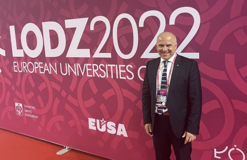 Zdjęcie portretowe: Adam Roczek na tle ścianki EUG.