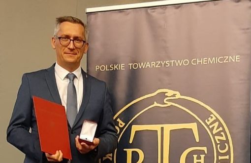 prof. Łukasz Albrecht prezentuje medal im. Stanisława Kostaneckiego i dyplom