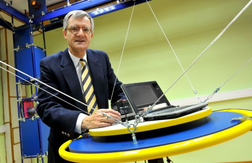 Prof. Andrzej Bartoszewicz stoi przy stanowisko robotycznym