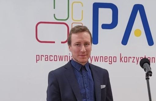 Mgr inż. Jan Makary Fryczak na tle ścianki reklamowej