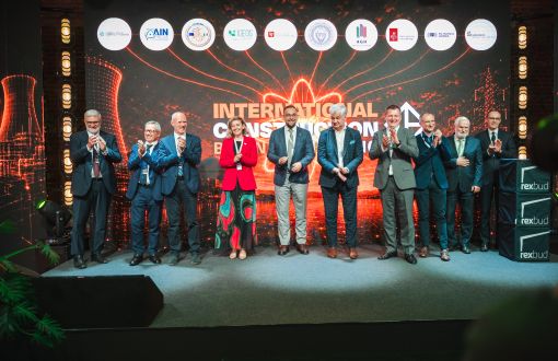Grupa dziesięciu osób na tle kolorowego banneru konferencji