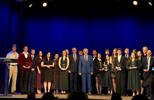 Grupa osób na scenie pozująca z nagrodami